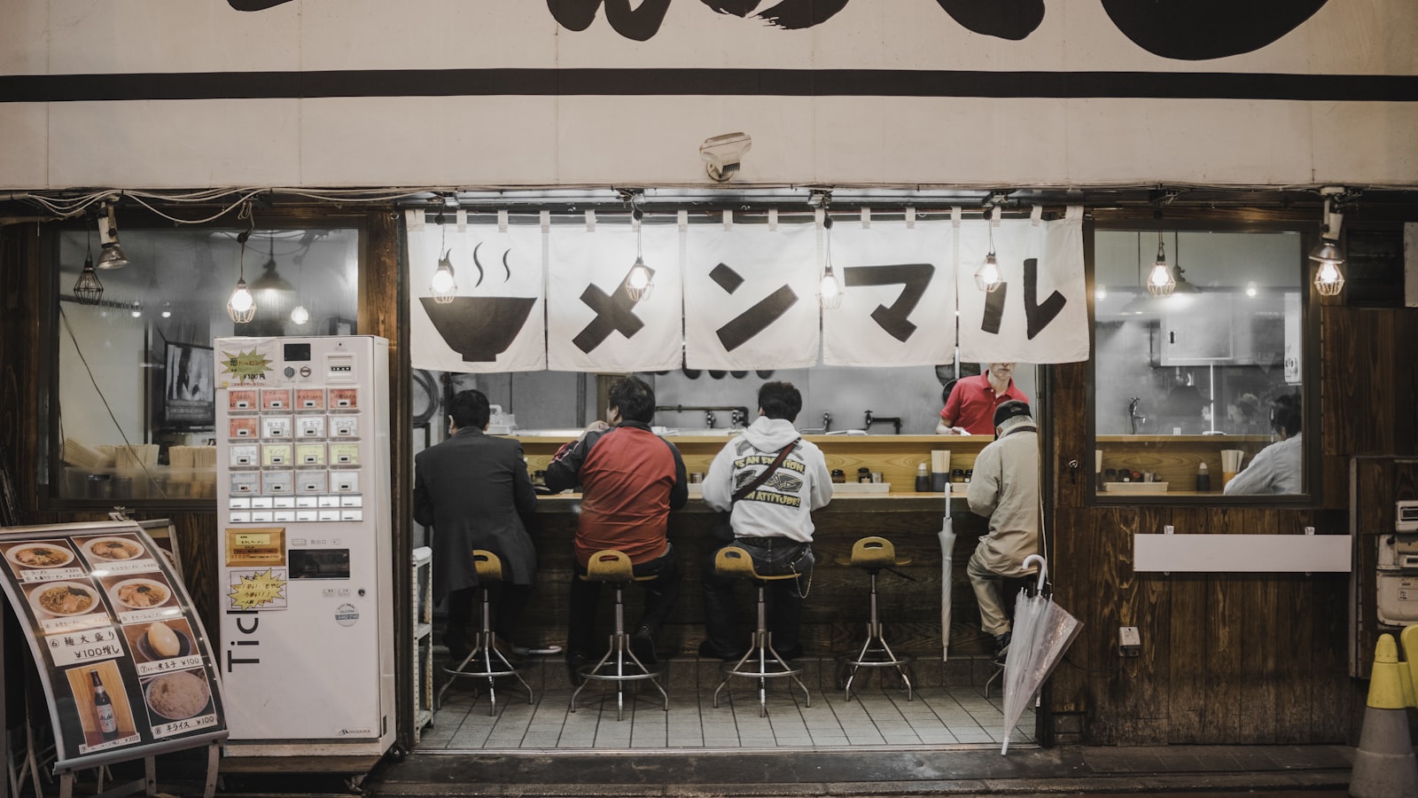 飲食店のカウンターに座る客たち