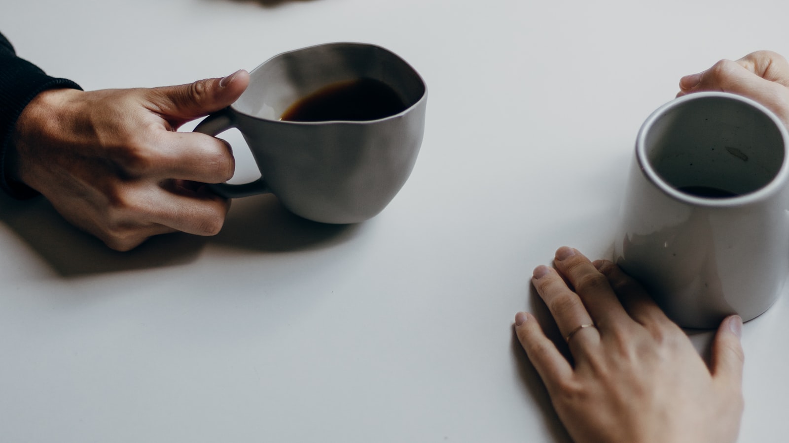 コーヒーを挟んで話す二人